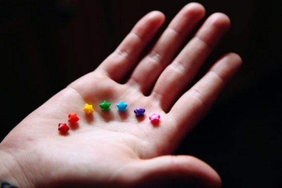 Sexuelle Vielfalt: Hand präsentiert 7 Zuckersternchen in Regenbogenfarben