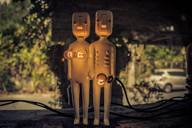 Kleines Figurenpaar von Mann und Frau aus weißem Porzellan, die Köpfe sind Lichtschalter, Genitalien als Mini-Glühbirnen dargestellt